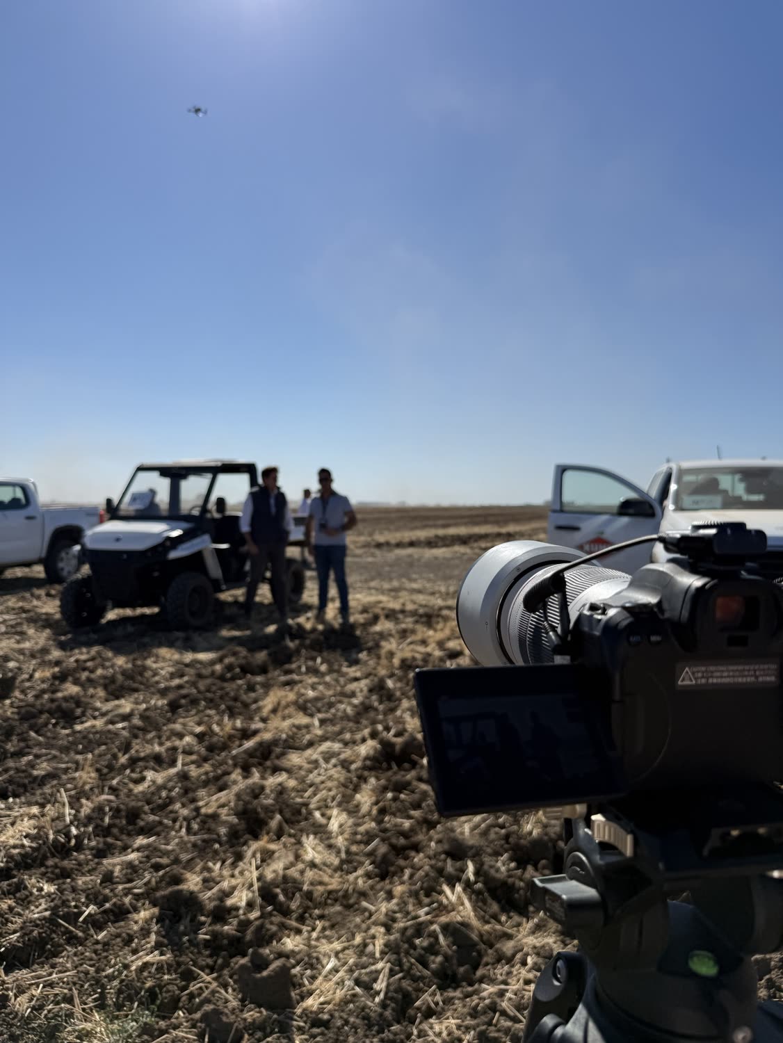 Rodaje en el campo con la cámara en primer plano y el dron en el aire
